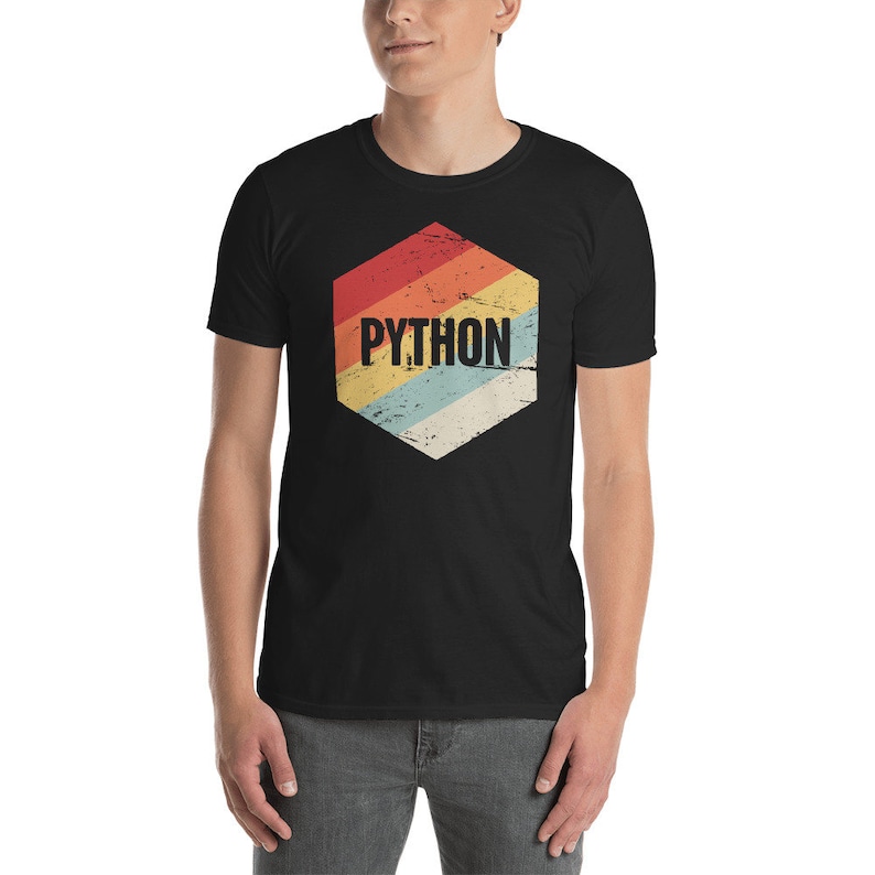 Peut inclure: Un t-shirt noir avec un design hexagonal de style r&eacute;tro comportant le mot "PYTHON" en texte blanc. L'hexagone a un sch&eacute;ma de couleurs arc-en-ciel d&eacute;lav&eacute;.
