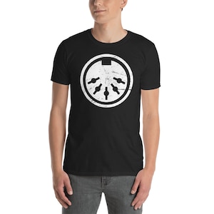 May include: A black t-shirt with a white distressed graphic of a 5-pin DIN connector. The connector is a common interface for electronic devices.