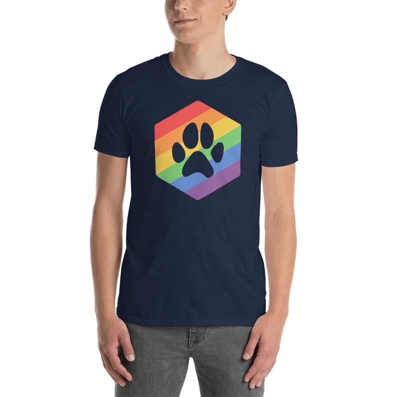 Peut inclure: Un t-shirt bleu marine avec une empreinte de patte arc-en-ciel dans un hexagone.