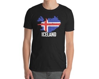 Könnte beinhalten: Ein schwarzes T-Shirt mit einem verwaschenen Umriss von Island, der mit den Farben der isländischen Flagge gefüllt ist. Der Text "Island" ist unter dem Umriss gedruckt.
