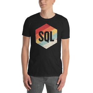 May include: A black t-shirt featuring a retro-style hexagon design with the text "SQL" in white. The hexagon has a faded rainbow colour scheme.