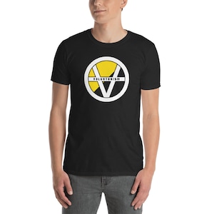 May include: Black t-shirt with a white circle containing a yellow V and the word "VOLUNTARISM" in black text.
