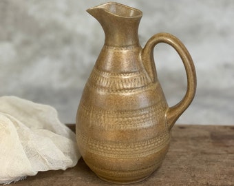 Una ánfora de cerámica rústica de estilo primitivo, de color marrón, hecha a mano para servir vino.