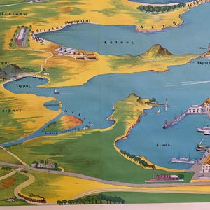 May include: A vintage map illustration featuring a coastal landscape with blue waters, yellow land, and green vegetation. The map includes Greek text, depicting bays, towns, and geographical features. The map is framed in a light brown wooden frame.