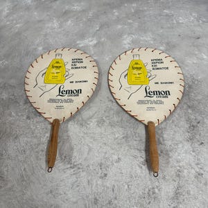 Anúncio vintage de leque de mão em papelão, leque de mão grego Adelco dos anos 1960, impressão retrô para colecionadores e presentes nostálgicos.