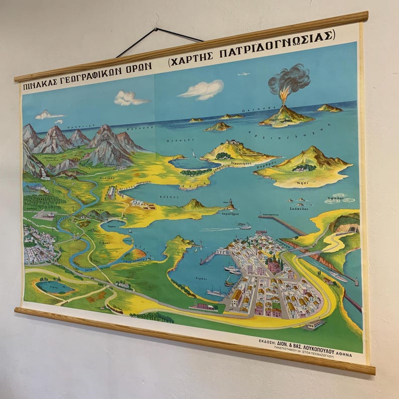 May include: A vintage Greek geography map with a wooden frame. The map features a detailed illustration of a coastal region with mountains, islands, and a town. The map has Greek text at the top and bottom.