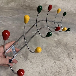 May include: A chrome coat rack with multiple hooks. The hooks are topped with colorful plastic balls in red, yellow, and green.