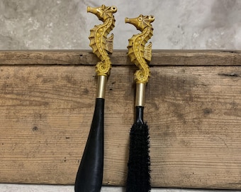 Calçadeira e escova vintage em formato de cavalo-marinho: seção central em metal com orifício para pendurar, facilitando o armazenamento.