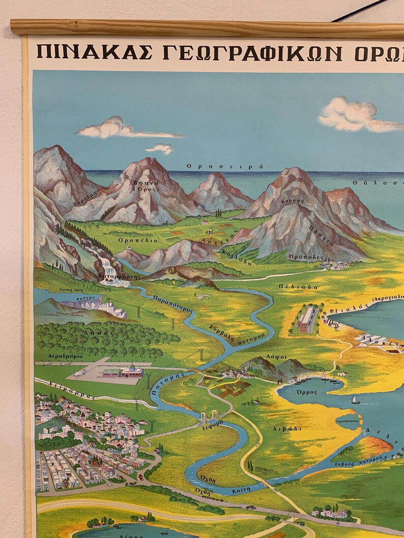 May include: Vintage Greek geographical map poster with text in Greek. The map depicts mountains, rivers, and coastal areas in a colorful, illustrated style. The poster is mounted on a wooden rod for hanging.