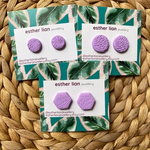 May include: Three pairs of lilac stud earrings with textured patterns are presented on cards with a green leaf design. The cards display the text "esther lian jewellery" and the Etsy shop's social media details.