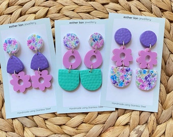 Clay and acrylic drops. Flower garden with purples/turquoise. Lift your outfit and start a conversation with these earrings!