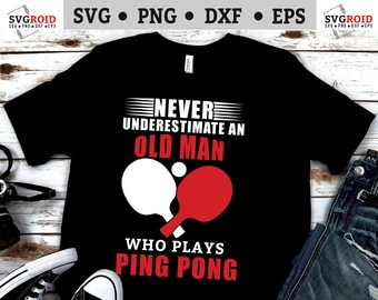 May include: A black t-shirt with white text that reads "Never underestimate an old man who plays ping pong". The text is surrounded by a graphic of two ping pong paddles.