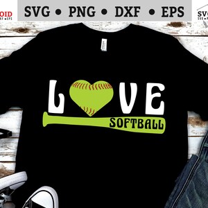May include: Black t-shirt with the text "LOVE SOFTBALL" in white letters. A green softball bat is under the text. A green softball with red stitching is in the shape of a heart.