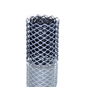 May include: A rolled silver metal mesh with a diamond pattern, wrapped around a darker material. The mesh is shown against a white background, emphasizing its texture and form. The mesh is likely used for protection or support.