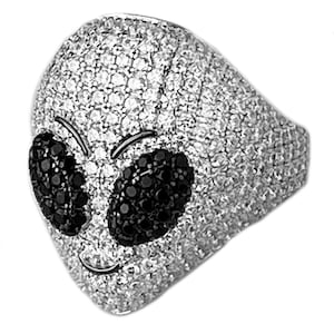 May include: A silver ring with a detailed alien face design. The alien's eyes are black and the face is covered in small, sparkling stones.