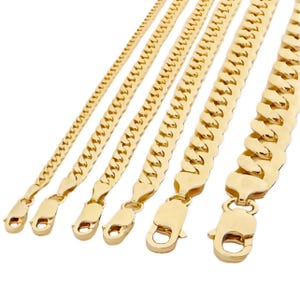 May include: Five gold chains of different widths and lengths. The chains are made of a thick, solid gold material and have a classic curb link design.