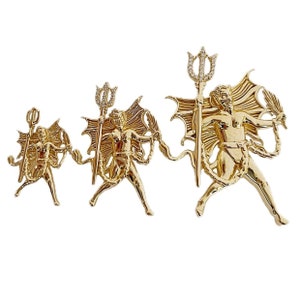 May include: Three gold-toned pendants featuring a devil-like figure holding a trident. The pendants are of different sizes and feature intricate details, including wings and chains.