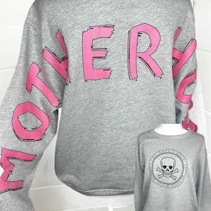 May include: A heather gray long-sleeve sweatshirt featuring the word MOTHER in large, distressed pink lettering across the back. A smaller inset shows the front of the same gray sweatshirt with a black circular graphic of a skull and crossbones.