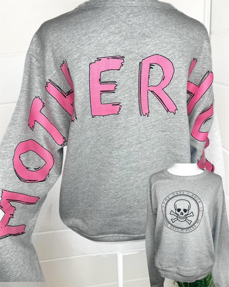 May include: A heather gray long-sleeve sweatshirt featuring the word MOTHER in large, distressed pink lettering across the back. A smaller inset shows the front of the same gray sweatshirt with a black circular graphic of a skull and crossbones.