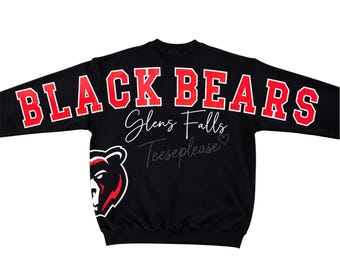 Könnte beinhalten: Ein schwarzes Langarm-Sweatshirt mit dem Text "BLACK BEARS" in fetten roten Buchstaben oben. Darunter stehen "Glens Falls" und "Teeseplease" in weißer Schreibschrift. Eine Grafik eines Bärenkopfes befindet sich unten links.