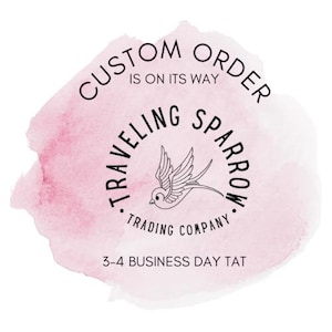 Pode incluir: Um fundo rosa em aquarela com o texto "CUSTOM ORDER IS ON ITS WAY" em uma fonte circular. Um gr&aacute;fico de p&aacute;ssaro est&aacute; no centro, rodeado pelas palavras "TRAVELING SPARROW TRADING COMPANY". O texto "3-4 BUSINESS DAY TAT" est&aacute; na parte inferior.
