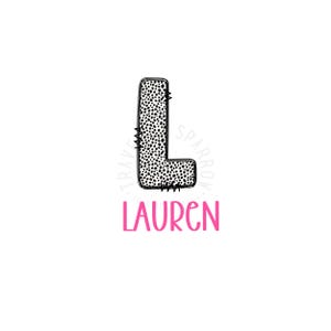 May include: Black and white polka dot letter L with a stitched border. The letter is surrounded by a circle with the text "Travel Sparrow Designs". Below the letter is the name "Lauren" in pink.