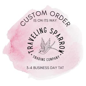 May include: A pink watercolor background with the text "CUSTOM ORDER IS ON ITS WAY" in a circle. Below the circle is the text "TRAVELLING SPARROW TRADING COMPANY" in a circle with a stylized sparrow illustration. The text "3-4 BUSINESS DAY TAT" is below the circle.