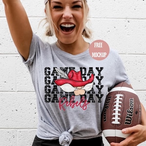 May include: Gray t-shirt with a black and white graphic of a cartoon rebel wearing a red hat and the text "Game Day Rebels".