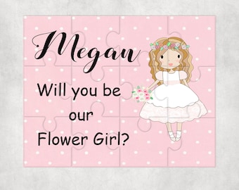 May include: A pink puzzle with white polka dots featuring a cartoon girl with blonde hair wearing a white dress and a flower crown. The text on the puzzle reads "Megan Will you be our Flower Girl?"