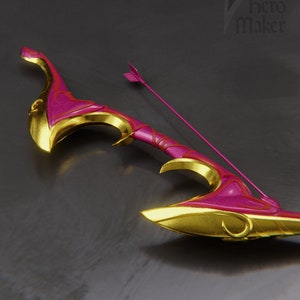 Puede incluir: Un arco rosa y dorado con un diseño decorativo y una flecha a juego. El arco está hecho de un material brillante y tiene una forma curva.