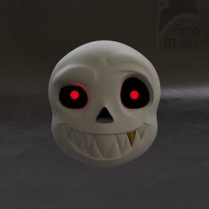 May include: A white skull mask with glowing red eyes and a wide, toothy grin. The mask has a single gold tooth and a small nose. The mask is likely for cosplay or costume use.
