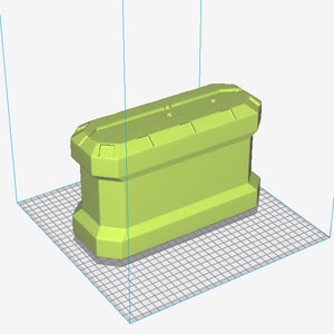 May include: A light green, rectangular container with a geometric design. The container has a series of rectangular shapes on the top and bottom. The object is sitting on a grid.