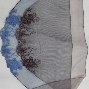 Puede incluir: Una bufanda azul y marr&oacute;n transparente con bordado floral. El bordado es en tonos azules y marrones.