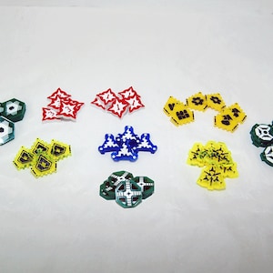 Puede incluir: Una colección de piezas de juego coloridas de varias formas y tamaños. Las piezas están hechas de plástico y presentan diferentes diseños, incluyendo estrellas, copos de nieve y engranajes.