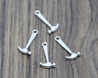 May include: Four silver-toned hammer charms with a loop at the top for attaching to jewelry or other crafts.