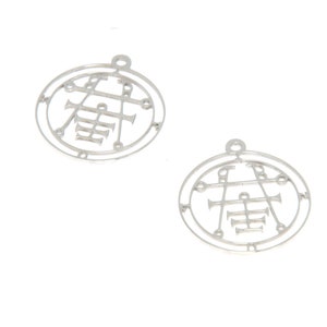 May include: Two silver metal charms with a circular design featuring a symbol inside. The symbol is a circle with lines and a cross inside.