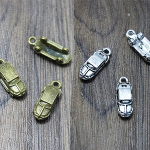 May include: Two sets of vintage car charms, one set in silver and one set in bronze. Each set includes four charms: a car, a truck, a bus, and a train. The charms are perfect for adding a touch of vintage style to your jewelry or crafts.
