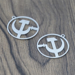 May include: Two silver metal charms in the shape of a circle with a hammer and sickle design inside.