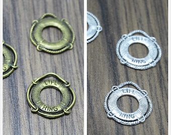 May include: Two sets of life ring charms, one set in antique gold and one set in silver. Each charm features the words "Life Ring" embossed on the surface.