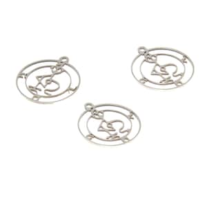 May include: Three silver metal charms with a circular design featuring a stylised symbol inside. The charms have a hole at the top for attaching to a necklace or bracelet.