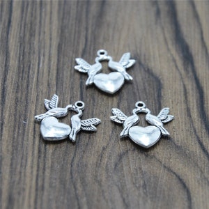 25 piezas de dijes de pájaros en tono plateado, colgantes con dijes de tortolitos y corazones, 22 x 21 mm