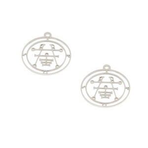 May include: Two silver metal charms with a circular design featuring a stylized symbol in the center. The symbol is surrounded by a circle with small dots around the edge.
