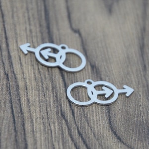 May include: Two silver metal charms in the shape of interlocking circles with an arrow pointing to the right inside each circle.