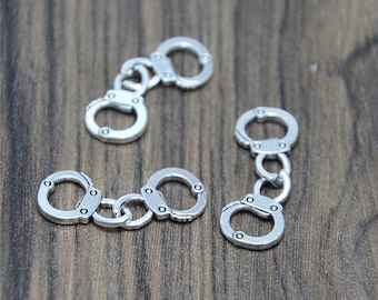 Pode incluir: Encantos de algemas de metal prateado, com um design ligado. Os encantos são pequenos e delicados, perfeitos para adicionar um toque de estilo ousado a projetos de joias.