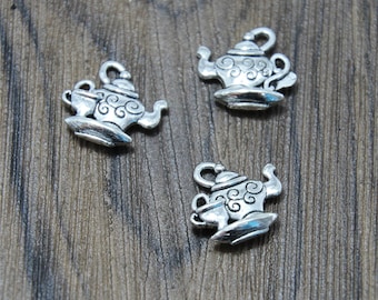 May include: Three silver teapot charms with intricate details. Each charm features a teapot with a small cup and a saucer.