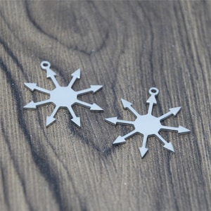 May include: Two silver metal charms in the shape of a star with eight points. Each point is an arrow pointing outwards.