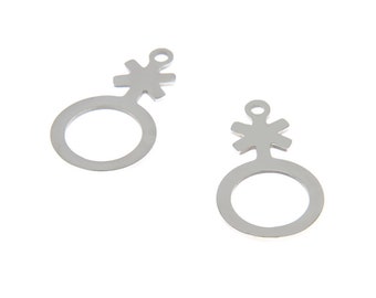 Puede incluir: Dos abalorios de metal plateado en forma de símbolo de género con un círculo pequeño y una estrella en la parte superior.