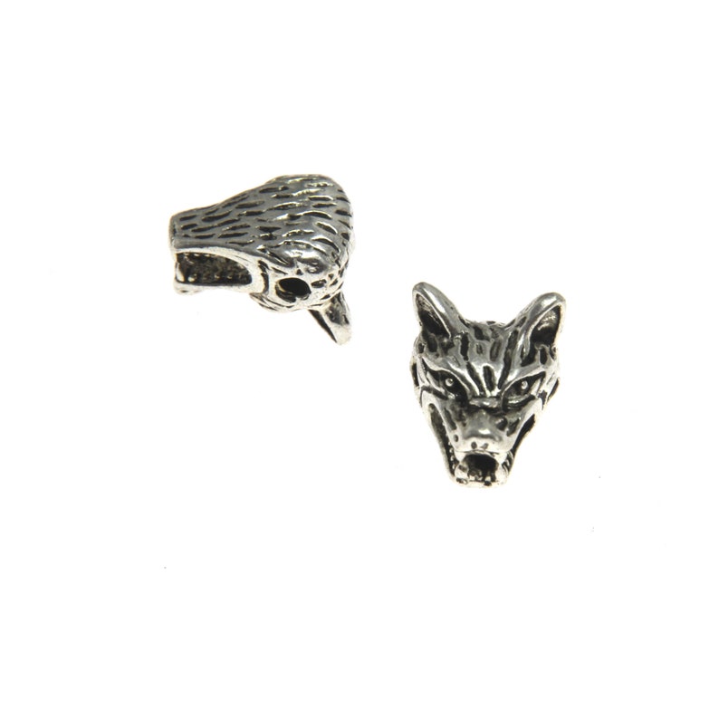 Peut inclure: Deux breloques en argent en forme de t&ecirc;te de loup. Un charme est face avant avec la bouche ouverte, l'autre charme est de c&ocirc;t&eacute; avec la bouche ferm&eacute;e.