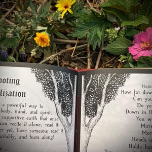 Op de afbeelding: Een open boek met zwart-wit illustraties van een boom. De tekst op de pagina luidt "Doting lization a powerful way to body, mind, and spirit, supportive earth that once can recite it alone, read it er yet, have someone read it ortably, and hum along! e.... Foot of a giant tree. full of bees. Hum How far dow Can you Do yo Down in th You w MOTE Mot Reach o Holds har You are part of som Nothing is h"