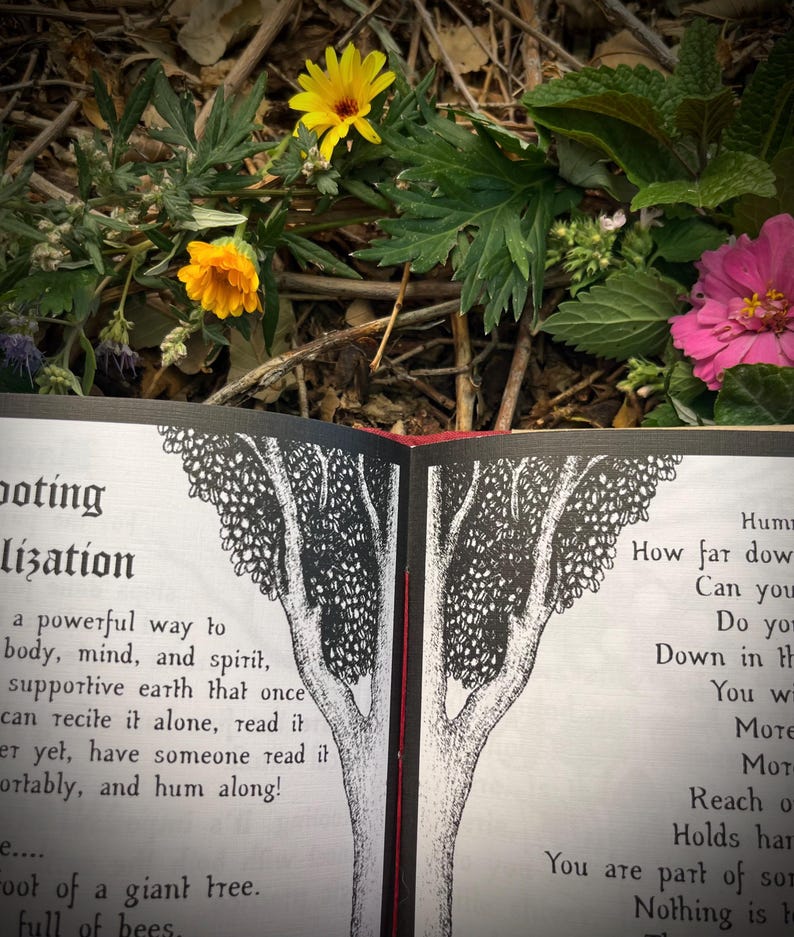 Op de afbeelding: Een open boek met zwart-wit illustraties van een boom. De tekst op de pagina luidt "Doting lization a powerful way to body, mind, and spirit, supportive earth that once can recite it alone, read it er yet, have someone read it ortably, and hum along! e.... Foot of a giant tree. full of bees. Hum How far dow Can you Do yo Down in th You w MOTE Mot Reach o Holds har You are part of som Nothing is h"
